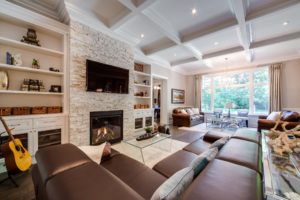 stone tv fireplace ideas cozy country cottage built in bookshelves bookshelf moulding living room waffle ceiling with pot lights leather couches